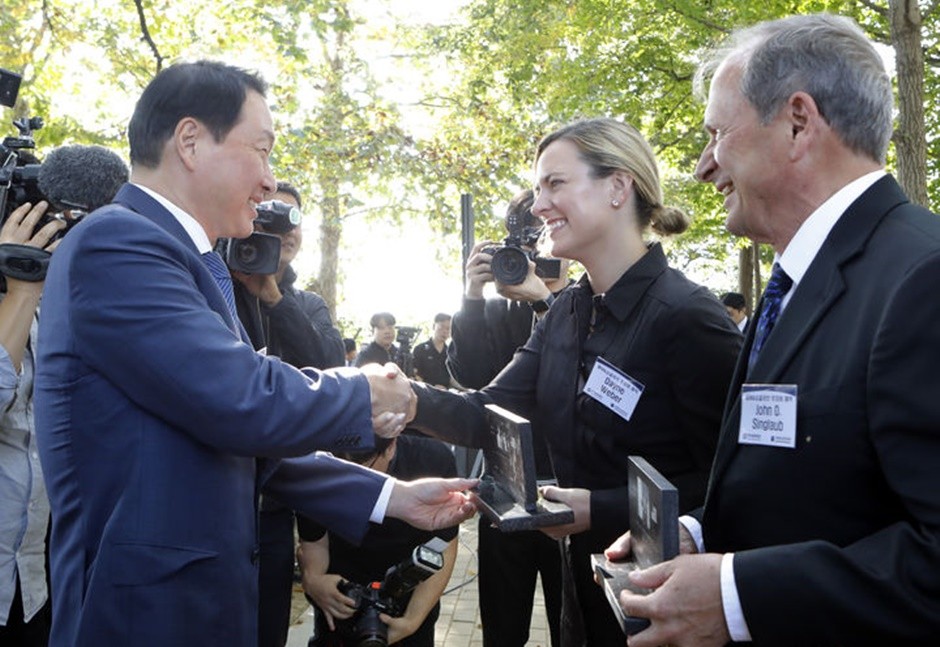 최태원 SK그룹 회장이 12일 오후 파주 임진각 보훈단지에서 열린 고(故) 윌리엄 E. 웨버(William E. Weber) 대령과 고 존 K. 싱글러브(John K. Singlaub) 장군의 추모비 제막식에 참석해, 유족인 데인 웨버(Dayne Weber)와 존 O. 싱글러브(John O. Singlaub)에게 추모비 축소 모형을 전달 받고 있다. [사진=SK]